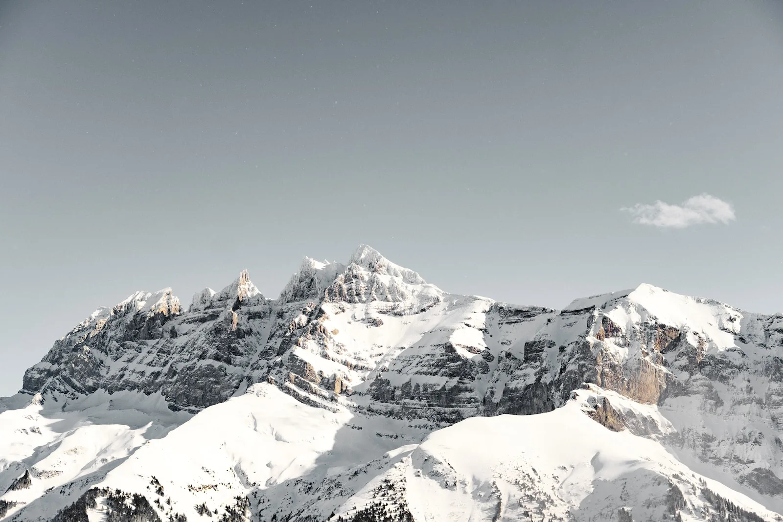 snow covered by mountain during daytime